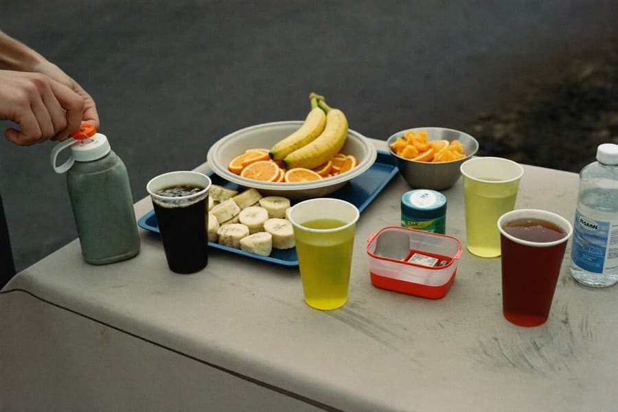 An aid station table with cut bananas, orange slices, and cups poured