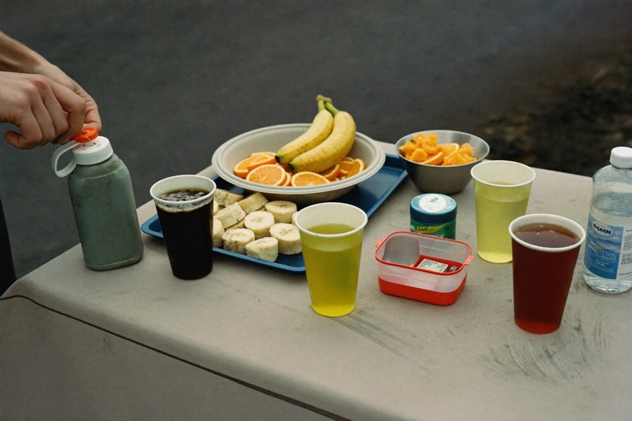 An ultra aid station table: cut bananas and oranges, paper cups of soda, salt tabs